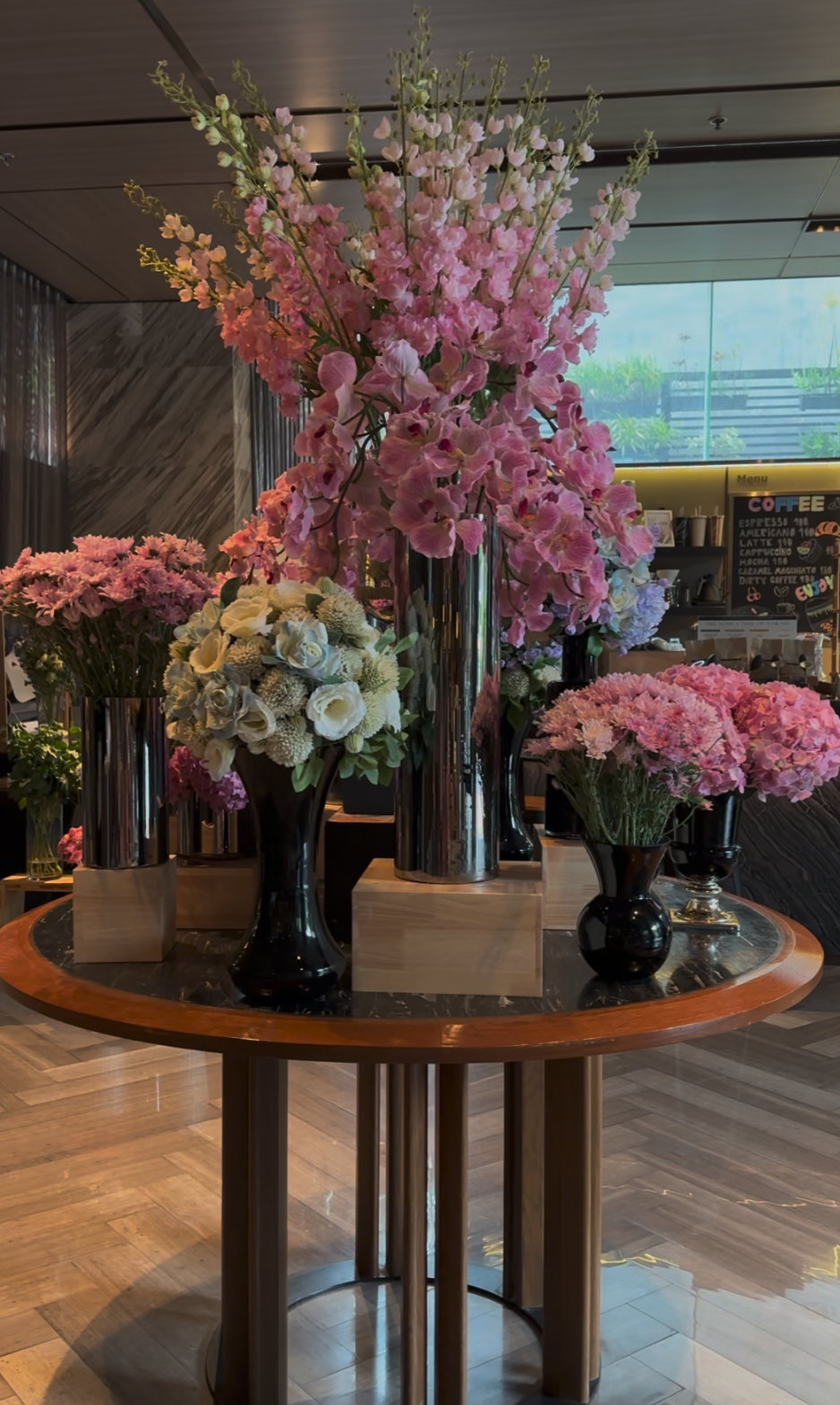 분홍색과 흰색 꽃으로 꾸며진 VIE Hotel Bangkok 로비 중앙 테이블